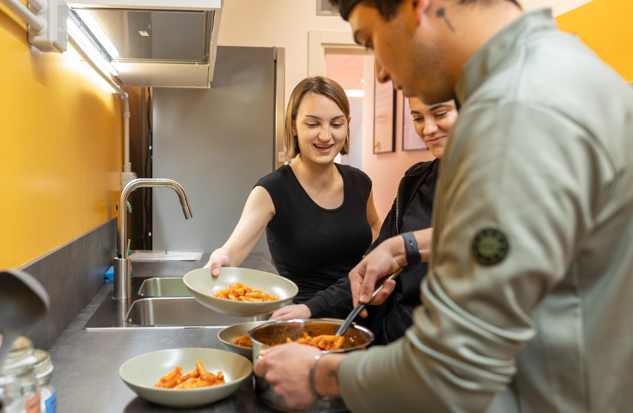 Cucina condivisa dettaglio con ragazzi che cucinano